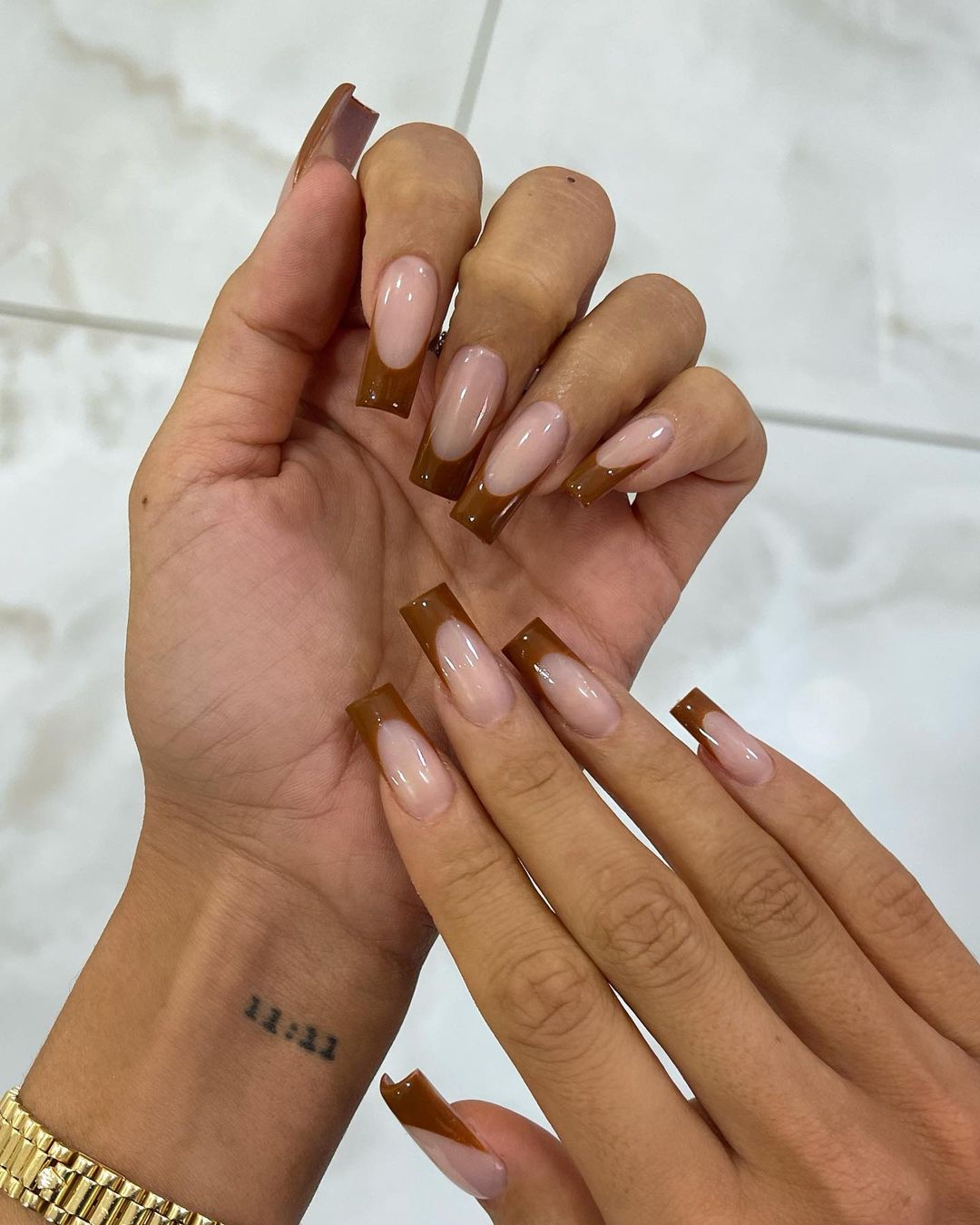 đôi tay da ngăm với bộ nail màu nâu hạt dẻ