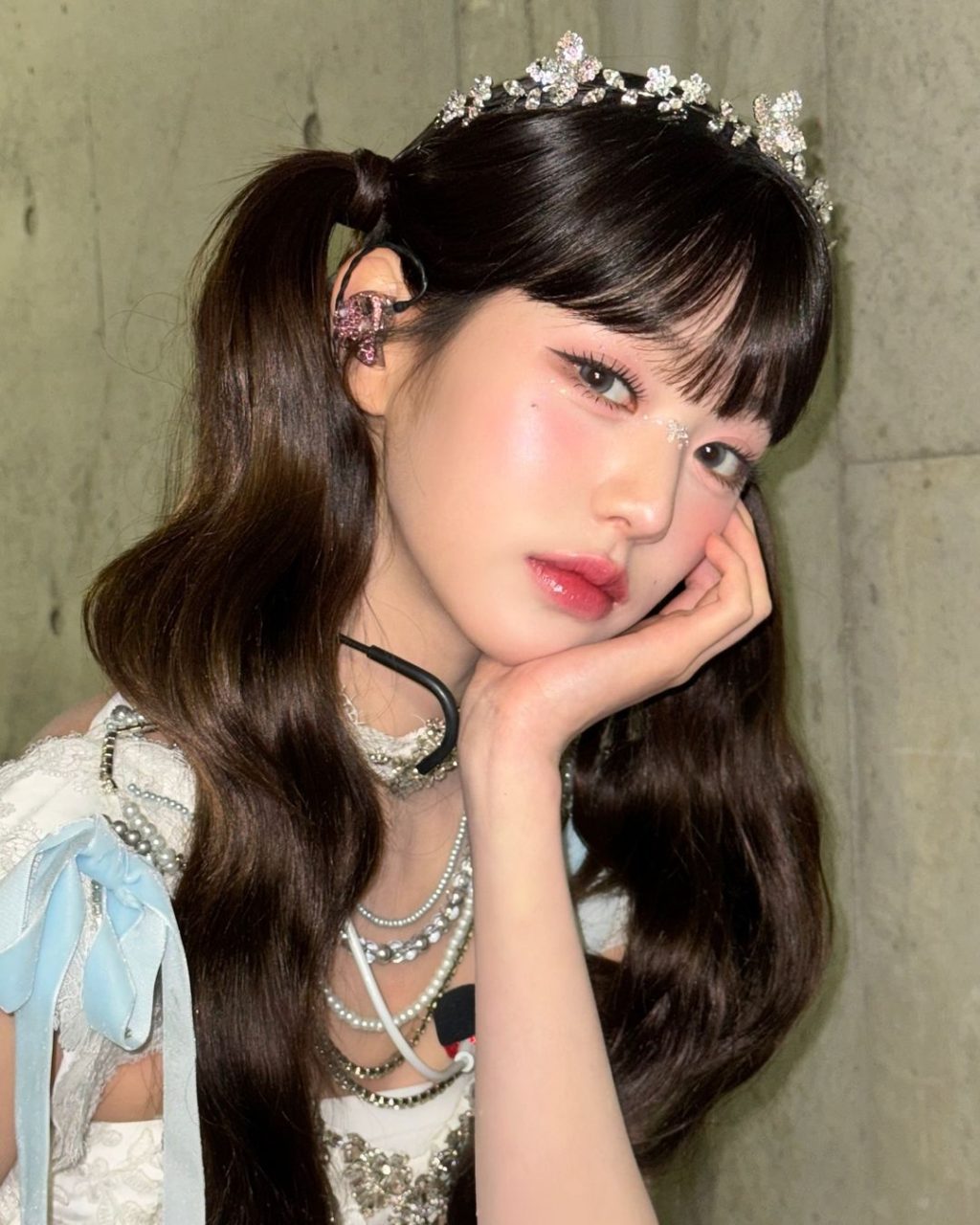 phấn mắt - Jang Wonyoung tạo kiểu buộc tóc hai bên, để mái thưa và trnag điểm tone hồng pastel để selfie góc nghiêng